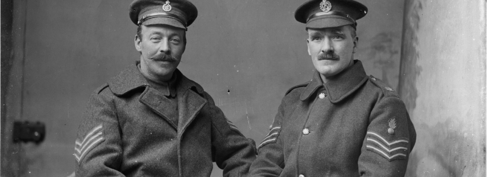 two moustachioed sergeants in greatcoats and peaked caps